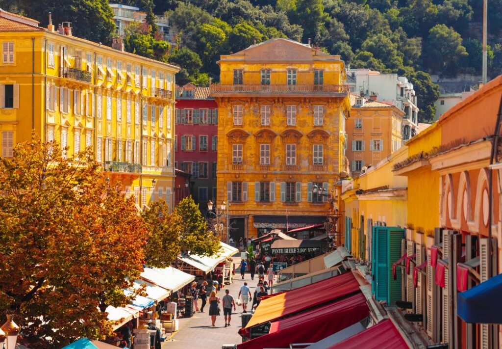 Strade strette e colorate della Vieux Nice con banchi del mercato di Cours Saleya e palazzi storici barocchi